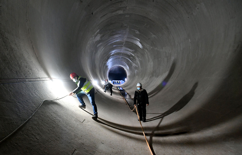工作人员正在向家坝灌区北总干渠一期工程龙洞岩隧洞工程内检查电缆 